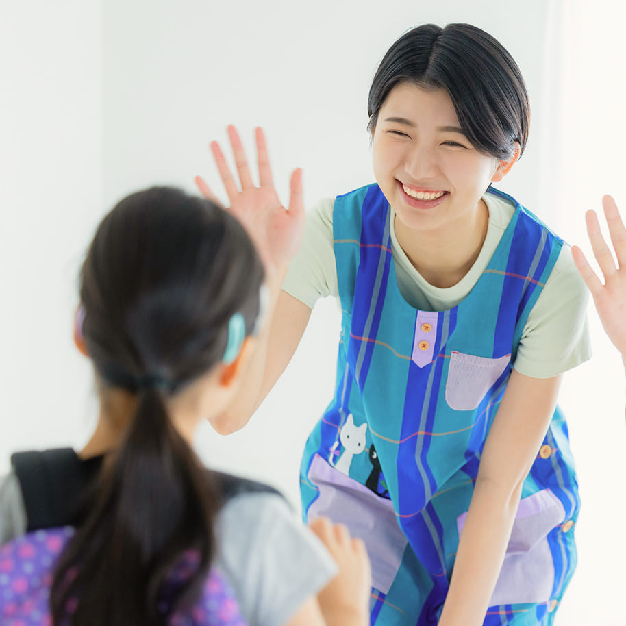 笑顔で手を振る子どもとスタッフ